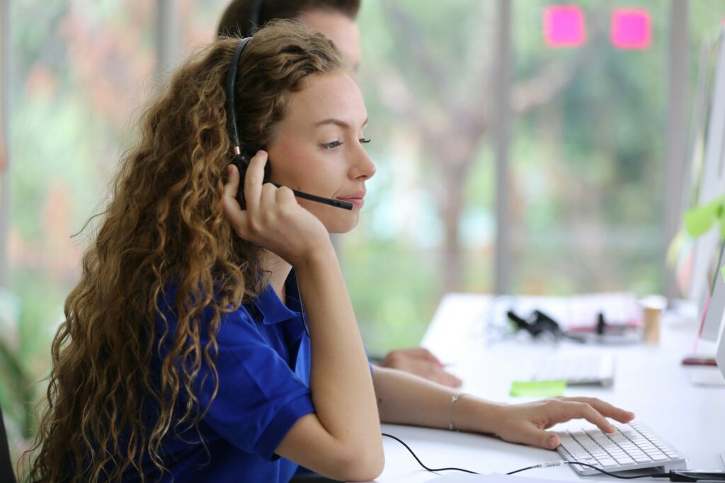 Female tech support operator with blue t-shirt uniform and black headset